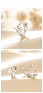 Detail view of silver flower hoop earrings with white zircon on silk background