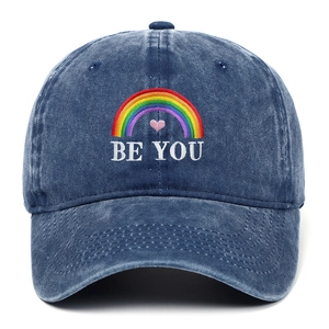 Close-up of rainbow and Be You embroidery on a dark blue washed denim baseball cap