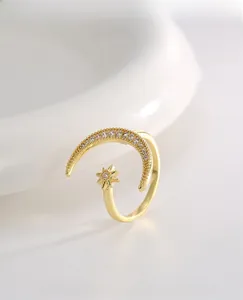 Macro shot of 18K gold star and crescent moon ring with sparkling zircon pavé detail