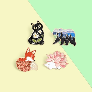 Set of four cute animal enamel pins featuring a cat, bear, fox, and hedgehog on a dual-tone background