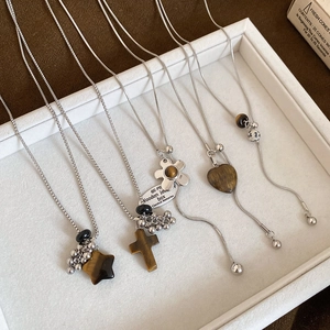 Close-up of geometric tiger eye pendants in star and heart shapes on silver chains