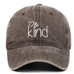 Detailed view of white Be Kind heart embroidery on vintage washed dark brown baseball cap