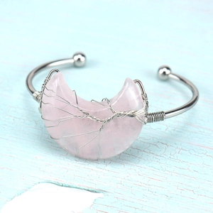 Detail of silver wire wrapped pink crystal crescent moon and tree of life on C-shaped cuff