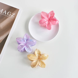 Detailed view of three 7cm colorful plumeria flower hair claws in pink, purple and yellow