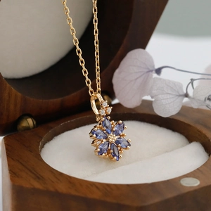 Détail du poinçon S925 sur un collier pendentif fleur dorée serti de tanzanites