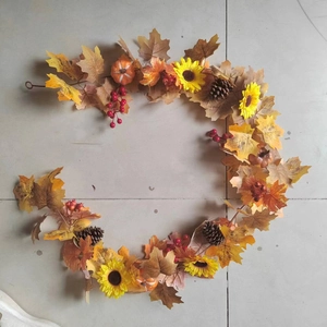 Detail of autumn maple leaf garland with sunflowers, pine cones, and decorative berries