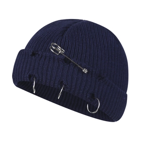 Distressed dark blue knit beanie with metal rings and large safety pin in punk style