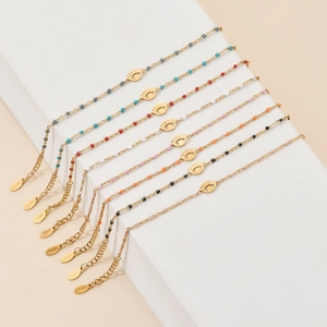 Golden stainless steel evil eye bracelet set with multi-color beads on a white stone