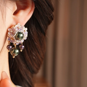 Detailed close-up of vintage resin floral earrings with pearls and metallic green accents