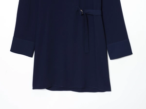 Détail de la robe courte bleu marine avec ceinture à boucle métallique et manches longues