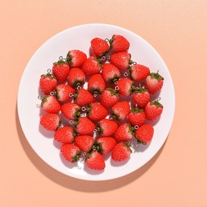 Pile of realistic resin strawberry pendants with metal loops for DIY jewelry making