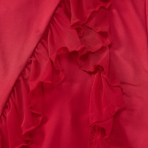 Detailed close-up of red ruffled edges and mesh fabric texture on the slit dress