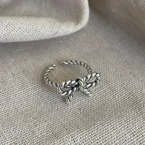 Close-up of vintage 925 silver bow ring with twisted rope texture and adjustable opening
