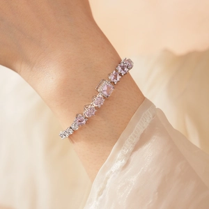 Macro detail of square cut pink zircon bracelet with silver setting on model wrist