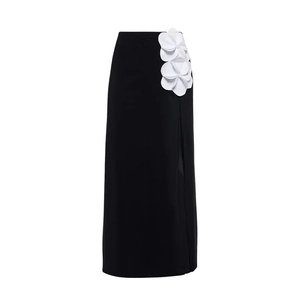 Detail of high waist black maxi skirt featuring three 3D white camellia flowers and side slit
