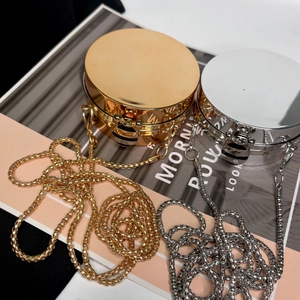 Detail of round metallic evening bags featuring a bee-shaped clasp in gold and silver