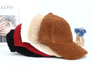 Detailed plush texture of various solid color faux shearling baseball caps in a stack
