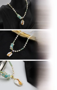 Detail view of baroque pearl pendant with 18K gold leaf inlay on handmade beaded necklace