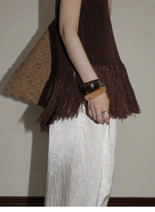Close-up of Maillard style wide resin bracelet paired with textured fringe knitwear