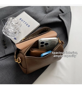 Sac cylindrique en cuir marron montrant la capacité intérieure et ferrures dorées