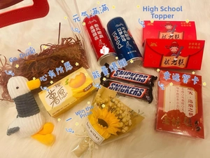 Close-up of exam gift box with plush duck, sunflowers, snacks, and soda for good luck