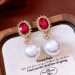 Vintage royal style earrings with red stones and large pearls on gold-toned metal
