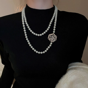 Détail du collier de perles multicouche avec pendentif fleur de camélia serti de diamants