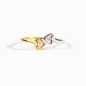 Elegant s925 silver two-tone heart ring with sparkling zircons on a white background