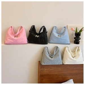 Detail of elegant chain shoulder bags in five colors with metallic butterfly ornaments