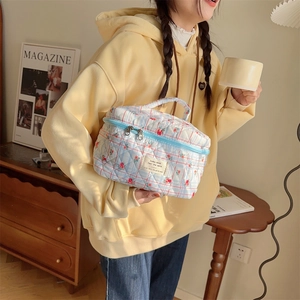 Détail de la trousse de maquillage matelassée fleurie avec double fermeture éclair