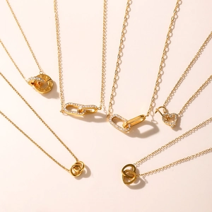 Kollektion goldener Titanstahlketten mit Doppelringen und Herzanhängern für Damen