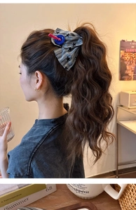Detail of cute striped fabric hair scrunchie with button accents on a ponytail