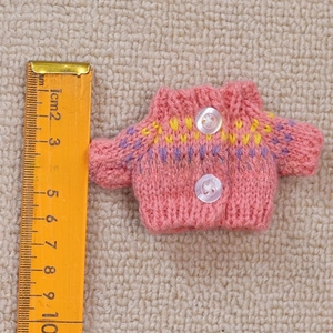 Pink miniature knitted sweater doll clothes with white buttons and colorful patterns