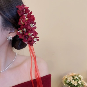 Detailed back view of vintage silk flower hair pin with long red streaming ribbons