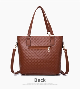 Back view of brown quilted tote bag with a functional zipper pocket and adjustable strap