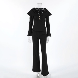 Detail of black elegant women's suit featuring gold buttons and flared leg trousers