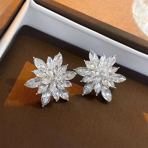 Detail of luxury silver flower studs with marquise-cut clear zircons on a jewelry box