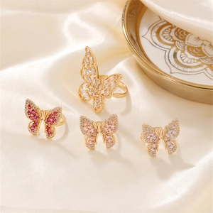 Elegant butterfly open rings set with zircons and pearls on a luxury silk background