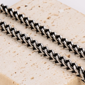 Rugged stainless steel Cuban link necklace for men displayed on a natural stone surface