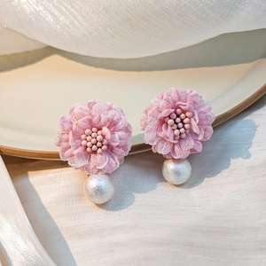 Detailed view of pink lace flower earrings with soft white pearls and mesh tassels
