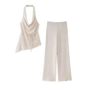 Dettaglio del top beige a fascia con bordo irregolare e pantaloni a gamba larga abbinati