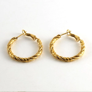 Close-up of golden spiral twisted texture on stainless steel hoop earrings