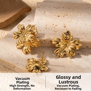 Macro view of gold flower earrings with layered petals on a textured stone base