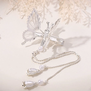 Detailed view of silver butterfly hair clip with tassel and lily of the valley pearl charms