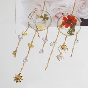 Detail of sun catcher featuring dried flowers in glass frames with crystal prisms