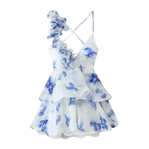 Détail d'une robe à fleurs bleues avec fleurs 3D en tissu sur la bandoulière
