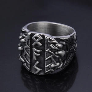 Detail of vintage Viking stainless steel ring featuring textured runic engravings on dark background