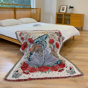 Bohemian butterfly woven blanket with floral patterns draped on a bed in a cozy room