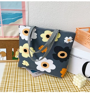 Canvas tote bag in dark gray featuring large floral print on a yellow checkered tablecloth