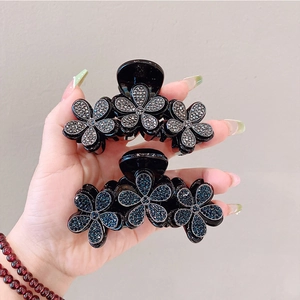Vista a mano di eleganti fermagli per capelli a fiore con strass grigi e blu
